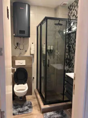 a bathroom with a shower and a toilet with a television at IN Apartman, Župa Kopaonik in Kopaonik