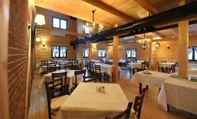 a dining room with white tables and chairs at IN Apartman, Župa Kopaonik in Kopaonik