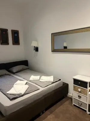 a bedroom with a bed with a mirror and a dresser at IN Apartman, Župa Kopaonik in Kopaonik