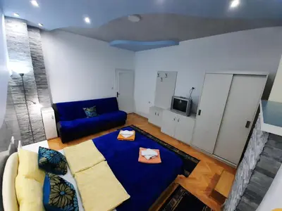 a living room with a blue bed and a couch at Smeštaj Milenković in Soko Banja