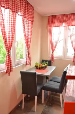 a dining room with red curtains and a table and chairs at Smeštaj Milenković in Soko Banja