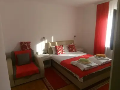 a bedroom with a bed and a chair at Smeštaj Milenković in Soko Banja