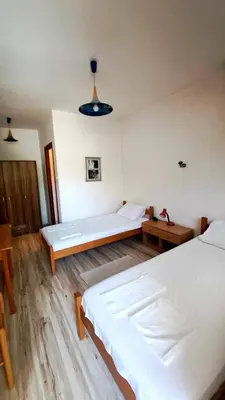 a room with two beds and a table in it at Šumatovac in Aleksinac