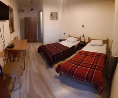 a hotel room with two beds and a desk at Šumatovac in Aleksinac