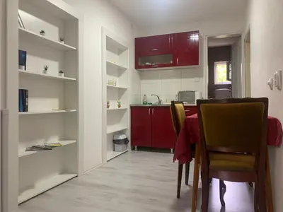 a kitchen with red cabinets and a table and chairs at Vlajkovic apartmani 2 in Vrnjačka Banja