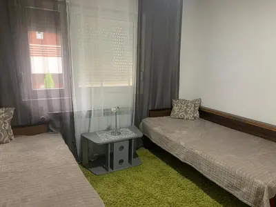 a room with two beds and a table between them at Vlajkovic apartmani 2 in Vrnjačka Banja