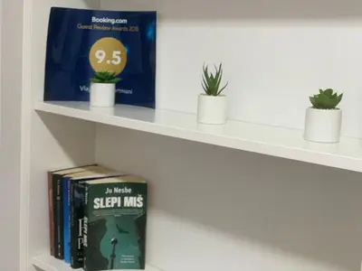 a shelf with books and potted plants on it at Vlajkovic apartmani 2 in Vrnjačka Banja
