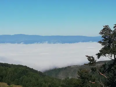 a view of a valley of clouds in the mountains at Apartman Adelfes P16, Milmari Resort in Kopaonik