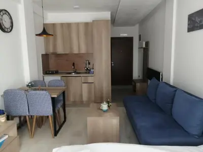a living room with a blue couch and a table at Apartman Adelfes P16, Milmari Resort in Kopaonik