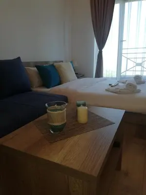a living room with a bed and a table with a candle at Apartman Adelfes P16, Milmari Resort in Kopaonik