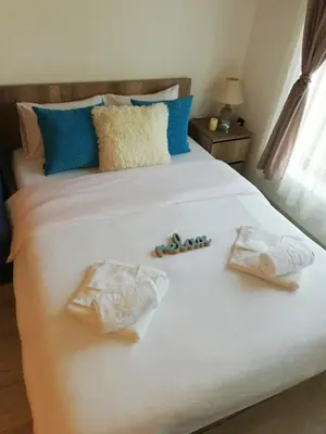 a bed with two towels and flip flops on it at Apartman Adelfes P16, Milmari Resort in Kopaonik