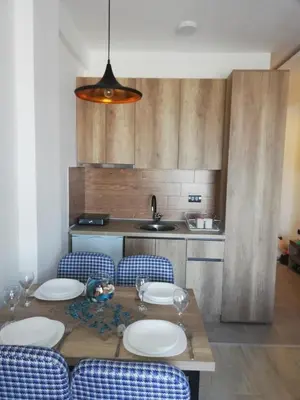 a kitchen with a table with chairs and a sink at Apartman Adelfes P16, Milmari Resort in Kopaonik