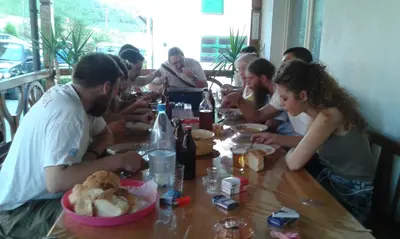 a group of people sitting around a wooden table at Seosko turisticko domaćinstvo Jagor in Despotovac