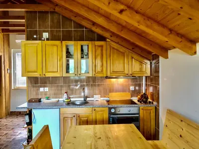 a kitchen with wooden cabinets and a wooden table at Seosko turisticko domaćinstvo Jagor in Despotovac