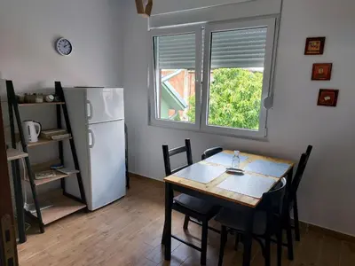 a dining room with a table and a refrigerator at Sokobanja Smeštaj Pavlović & privatan parking in Soko Banja