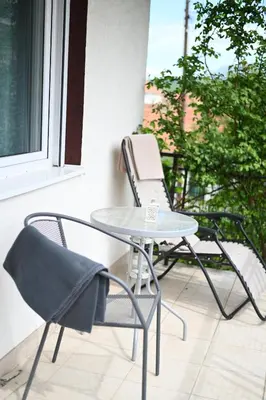 a table and chairs on a balcony with a laptop at Sokobanja Smeštaj Pavlović & privatan parking in Soko Banja