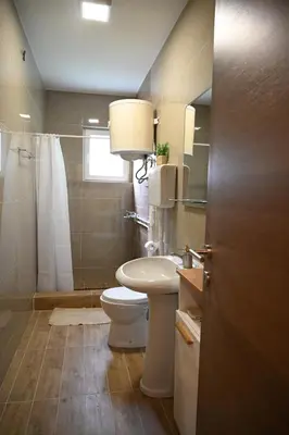a bathroom with a toilet and a sink and a shower at Sokobanja Smeštaj Pavlović & privatan parking in Soko Banja