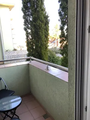 a balcony with a table and a chair and a window at Studio Mišel 2 in Vrnjačka Banja