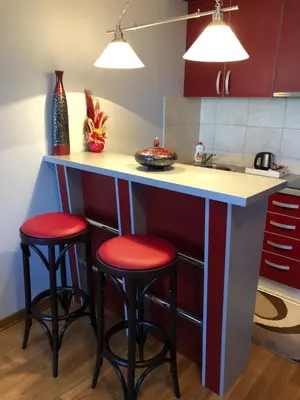a kitchen with red stools at a kitchen counter at Studio Mišel 2 in Vrnjačka Banja