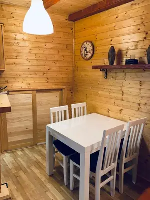 a dining room with a white table and chairs at Konaci apartman Hani in Kopaonik