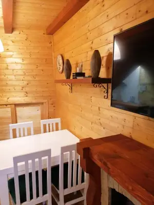 a dining room with a table and a flat screen tv at Konaci apartman Hani in Kopaonik