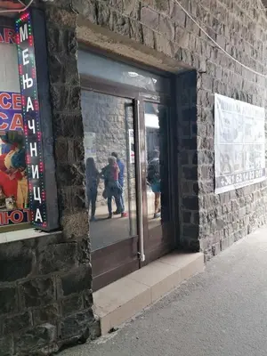 a door to a store with people walking in the street at Konaci apartman Hani in Kopaonik