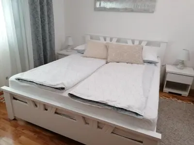 a white bed with white sheets and pillows on it at Apartman - Studio Prnic in Soko Banja