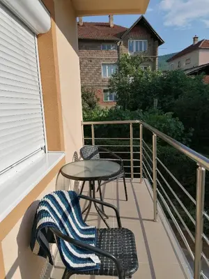 a balcony with two chairs and a table and a table at Apartman - Studio Prnic in Soko Banja