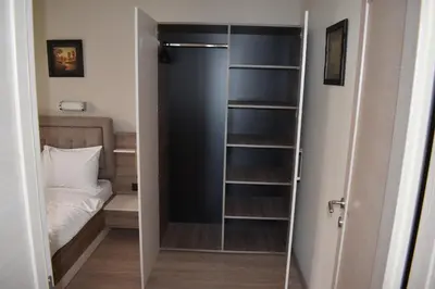 a closet with a glass door with a bed in it at Apartman G1 u Milmari kompleksu - Kopaonik in Kopaonik
