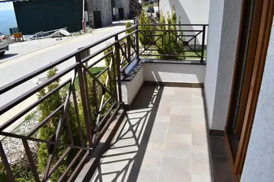 a balcony with a railing and shadows on the ground at Apartman G1 u Milmari kompleksu - Kopaonik in Kopaonik