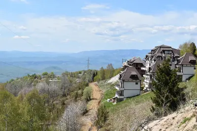 a group of houses on the side of a hill at Apartman G1 u Milmari kompleksu - Kopaonik in Kopaonik