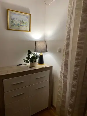 a lamp sitting on top of a dresser in a room at Apartmani CENTAR Vrnjacka Banja & Free Parking in Vrnjačka Banja