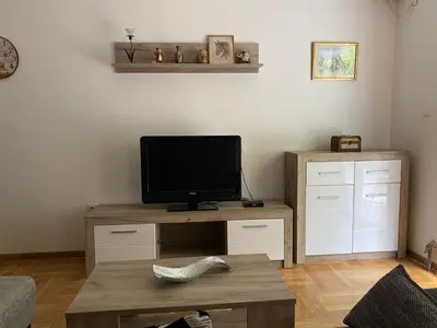 a living room with a television on a wooden table at Apartmani CENTAR Vrnjacka Banja & Free Parking in Vrnjačka Banja