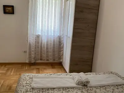 a bed sitting in a room with a window at Apartmani CENTAR Vrnjacka Banja & Free Parking in Vrnjačka Banja