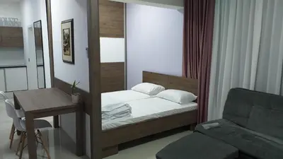 a bedroom with a bed and a desk and a couch at Dream House in Kruševac