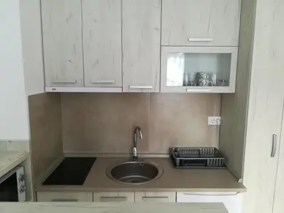 a kitchen with a sink and white cabinets at Vila Irina - Studio 15 lux in Kopaonik