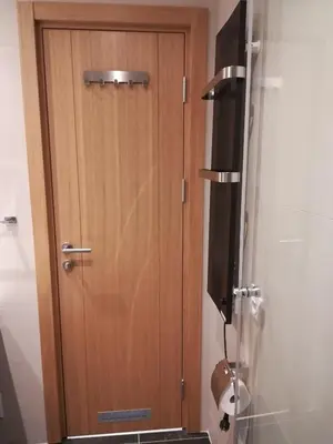 a wooden door in the corner of a bathroom at Vila Irina - Studio 15 lux in Kopaonik