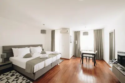 a bedroom with a large bed and a desk at Pegaz Holiday Resort in Vrnjačka Banja