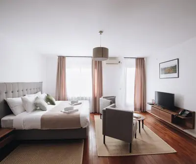 a bedroom with a bed and a chair and a television at Pegaz Holiday Resort in Vrnjačka Banja