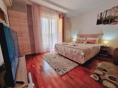 a bedroom with a bed and a flat screen tv at Apartman Temida Lux in Vrnjačka Banja