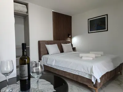 a bedroom with a bed with a bottle of wine and glasses at Nikolic Apartment 2 in Leskovac