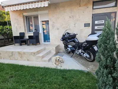 a motorcycle parked in front of a house with a dog at Nikolic Apartment 2 in Leskovac