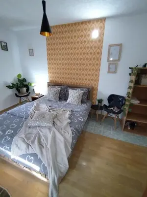a bedroom with a bed and a chair in it at STEFAN in Vrnjačka Banja