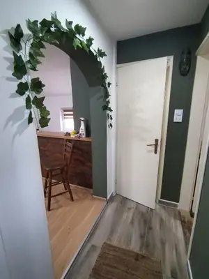a room with a table and a doorway with a green wall at STEFAN in Vrnjačka Banja