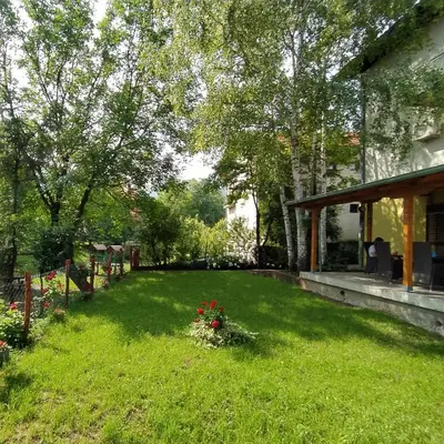 a yard with flowers in the grass next to a house at Apartmani Smiljanic Sokobanja in Soko Banja