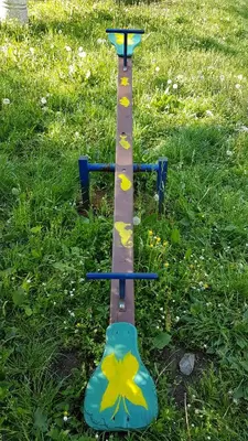 a bird feeder in the grass with flowers on it at Apartmani Smiljanic Sokobanja in Soko Banja
