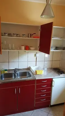 a kitchen with red cabinets and a sink at Apartmani Smiljanic Sokobanja in Soko Banja