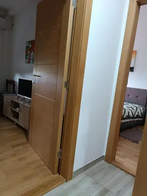 a door leading to a bedroom with a bed and a desk at Apartman Dana in Soko Banja