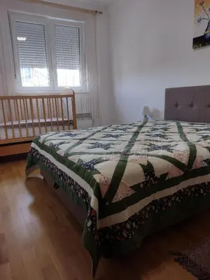 a bedroom with a bed with a quilt on it at Apartman Dana in Soko Banja