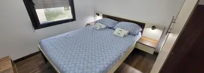 a bedroom with a bed with blue sheets and pillows at Duos East in Soko Banja
